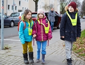 Drei Kinder zu Fuß auf dem Weg zur Schule.